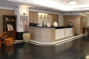 a woman standing at a counter in a hotel lobby at Hermes Hotel in Hsinchu City