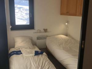 two beds in a small room with a window at Charmant 2 Pièces Rénové Val Thorens - 4 Pers, Ski aux Pieds, Balcon, Wi-Fi - FR-1-637-23 in Val Thorens