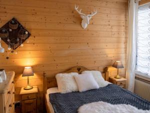 1 dormitorio con pared de madera, 1 cama y 2 lámparas en Appartement Val Thorens, 4 pièces, 6 personnes - FR-1-637-28, en Val Thorens