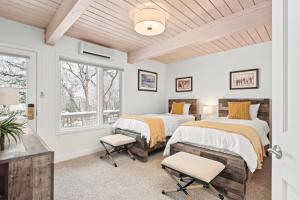 two beds in a room with two windows at Standard Two Bedroom - Aspen Alps #402 in Aspen