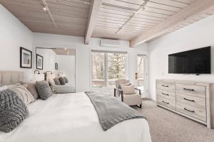 a white bedroom with a large bed and a tv at Standard Two Bedroom - Aspen Alps #402 in Aspen
