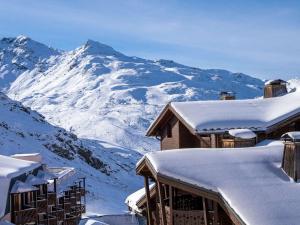 a snow covered mountain in front of a house at Appartement moderne à Val Thorens - 4 pers - 1 chambre, 1 cabine, skis aux pieds, balcon - FR-1-637-30 in Val Thorens +3 photos