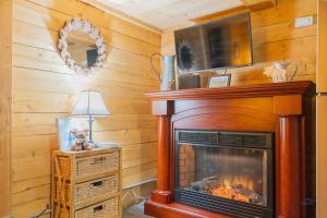una chimenea con TV encima en 1 Bd Deluxe Log Cabin View Northern Lights, en Fairbanks