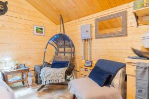 um quarto com uma gaiola para pássaros e duas cadeiras em Studio Log Cabin With Aurora Views em Fairbanks