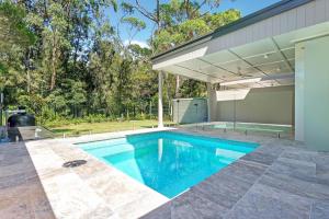 a swimming pool in the backyard of a house at Manzi Jervis Bay in Huskisson