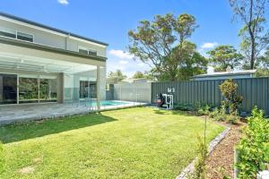an exterior view of a house with a yard at Manzi Jervis Bay in Huskisson