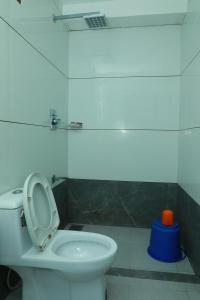 a bathroom with a toilet and a blue light at Relax Beach Inn in Cherai Beach