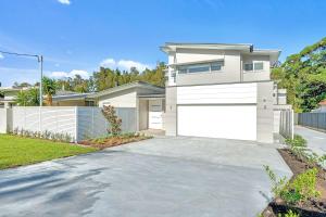a house with a driveway and a white garage at Ilanga Jervis Bay-Heated Pool in Huskisson