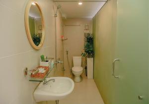 La salle de bains est pourvue d'un lavabo, de toilettes et d'un miroir. dans l'établissement Galaxy Boutique Sai Gon Central Hotel, à Hô-Chi-Minh-Ville