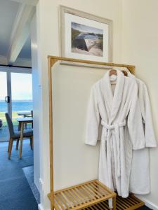 a robe hanging on a wall next to a mirror at Stanley Village Waterfront Accommodation in Stanley