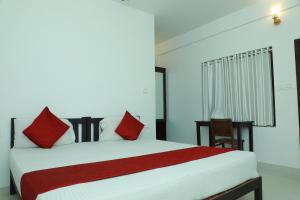 a bedroom with a large bed with red pillows at Relax Beach Inn in Cherai Beach