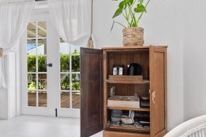 a cabinet in a living room with a plant on top at The Beach Hut in Vincentia