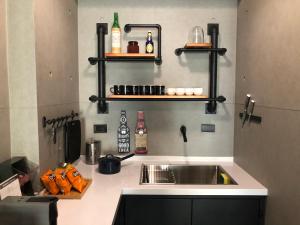 cocina con fregadero y estanterías en la pared en 洛夫特Looft包棟民宿, en Hengchun