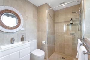 a bathroom with a toilet and a glass shower at Bliss the Beach Jervis Bay in Huskisson +7 photos