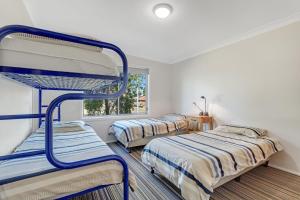 two bunk beds in a room with a window at Berry by The Bay in Vincentia