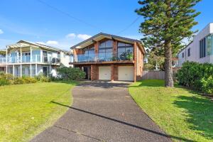 a house with a walkway in front of a yard at Beachcombers on Collingwood Beach in Vincentia