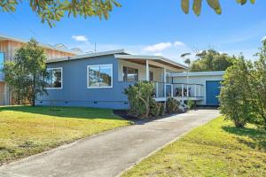 a home with a blue house with a driveway at Berry by The Bay in Vincentia