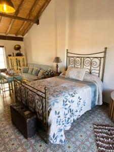 - une chambre avec un grand lit et un canapé dans l'établissement El Escondite de Martina, Áticos Románticos, à Setenil de las Bodegas