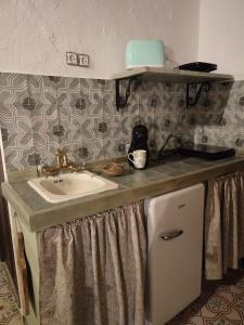 una encimera con lavabo en una habitación en El Escondite de Martina, Áticos Románticos en Setenil