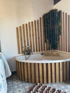 Cette chambre dispose d'une baignoire et d'un mur en bois. dans l'établissement El Escondite de Martina, Áticos Románticos, à Setenil de las Bodegas