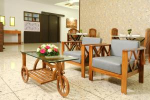 - un hall avec des chaises et une table fleurie dans l'établissement Serene Stay, à Alappuzha