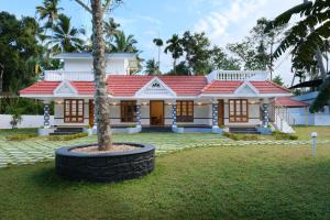 une maison avec un palmier en face dans l'établissement Serene Stay, à Alappuzha