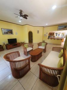 a living room with chairs and a couch and a tv at La Passe Holiday Villa in La Digue