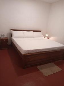 ein Schlafzimmer mit einem großen Bett mit weißer Bettwäsche in der Unterkunft Villa Arunodaya in Hikkaduwa