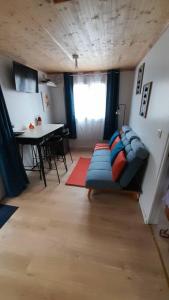 a living room with a blue couch and a table at Le Piton des Roches in La Plaine des Palmistes