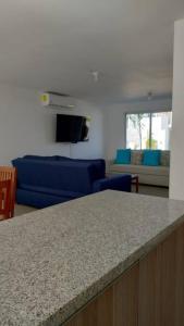 a living room with a blue couch and a counter top at Hermosa casa en Acapulco con club de Playa. in Acapulco