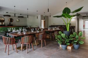 a restaurant with tables and chairs and potted plants at Sarana Hôtel & Spa in Salazie