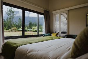 a bedroom with a large bed and a large window at Sarana Hôtel & Spa in Salazie