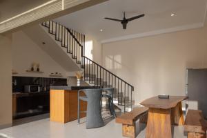 a living room with a table and a staircase at Villa Destino - Seminyak Bali in Seminyak