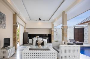 a living room with white furniture and a swimming pool at Villa Destino - Seminyak Bali in Seminyak