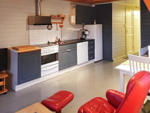 a kitchen with white appliances and a red chair at Two-Bedroom Holiday home in Gravdal 1 in Gravdal