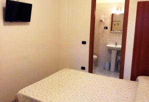 a small room with a bed and a sink at Hotel Ricci in Genoa