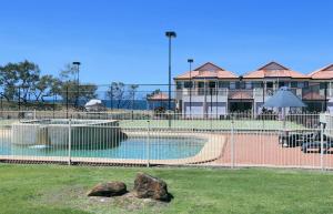 a swimming pool in front of a building at Villa 25 Coral Cove Resort in Bargara