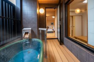 a bath tub in a bathroom with a mirror at KAMENOI HOTEL Ome in Ome
