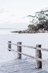 a wooden bridge on the beach with a fence at The Beach Studio in Huskisson
