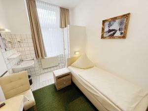 a small room with a bed and a sink at Boardinghouse Köln in Cologne