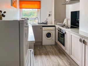 a kitchen with a washing machine and a dishwasher at Ivy Court Apartment in Rothesay