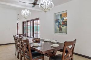 Un comedor con mesa y sillas de madera. en 10BHK Super Luxury Villa with Private Pool, en Calangute