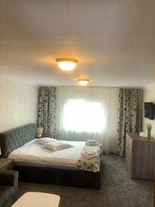 a bedroom with a bed and a window with curtains at BUCEGI VIEW APARTAMENT in Sinaia