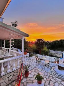 a patio with chairs and a sunset in the background at Holiday house near the beach - 2 in 1 in Perítheia