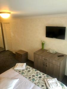 a hotel room with a bed and a flat screen tv at BUCEGI VIEW APARTAMENT in Sinaia