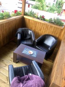2 stoelen en een salontafel in een kamer met een raam bij BUCEGI VIEW APARTAMENT in Sinaia