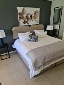 a large bed with white sheets and pillows in a bedroom at Umhlangha Oceans Dunes in Umhlanga