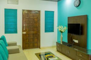 sala de estar con TV y puerta en Spacious 3 bhk new stylish villa in Vagator en Vagator