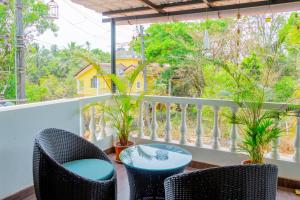 balcón con sillas, mesa y árboles en Spacious 3 bhk new stylish villa in Vagator en Vagator