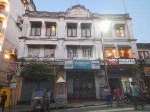 a building on a street with people standing in front of it at City View Hostel in Kandy